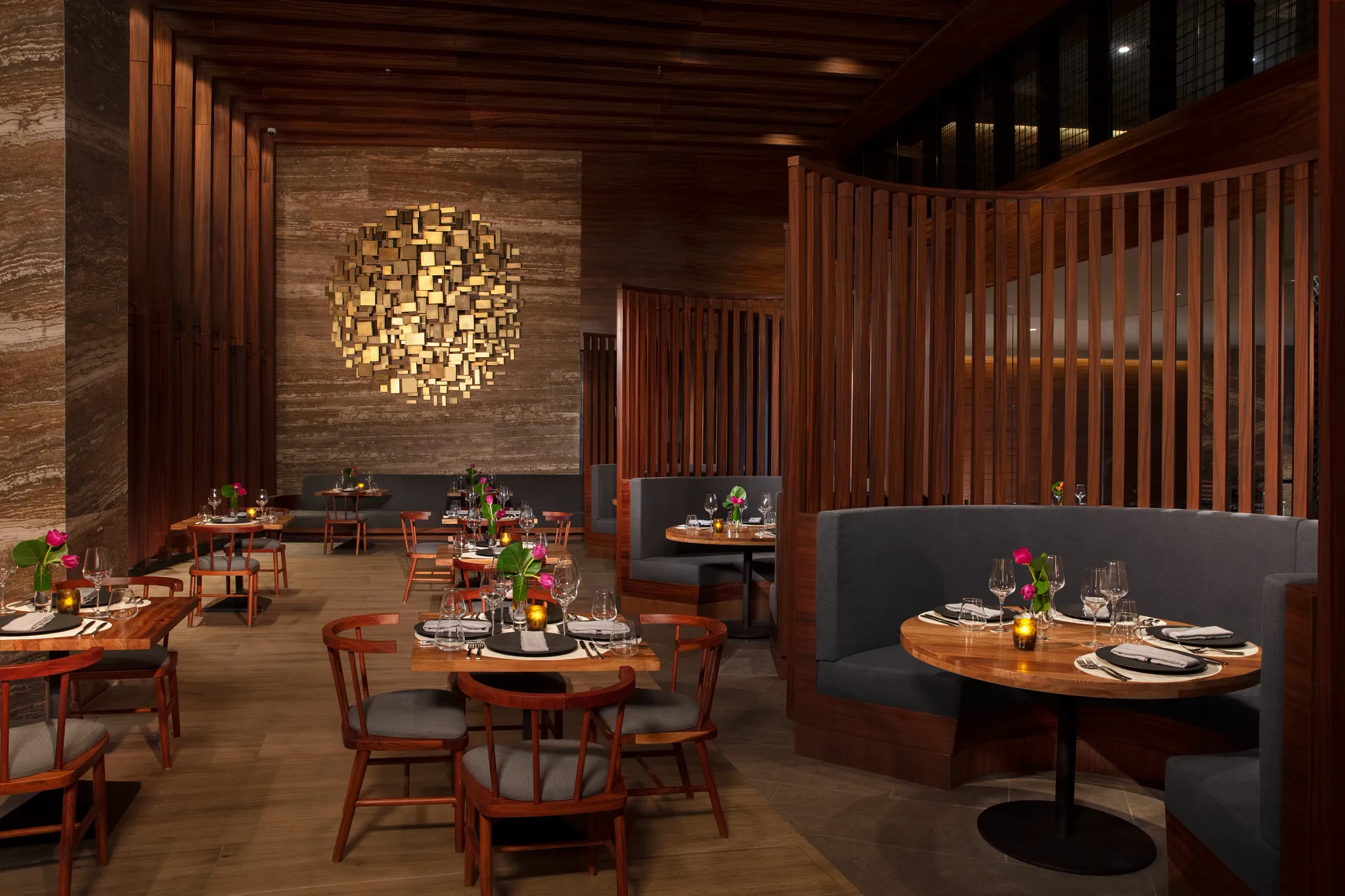 Bordeaux French Restaurant at Secrets Bahia Mita Surf & Spa Resort featuring an elegant dining room with warm wood accents, intimate seating, and refined table settings.