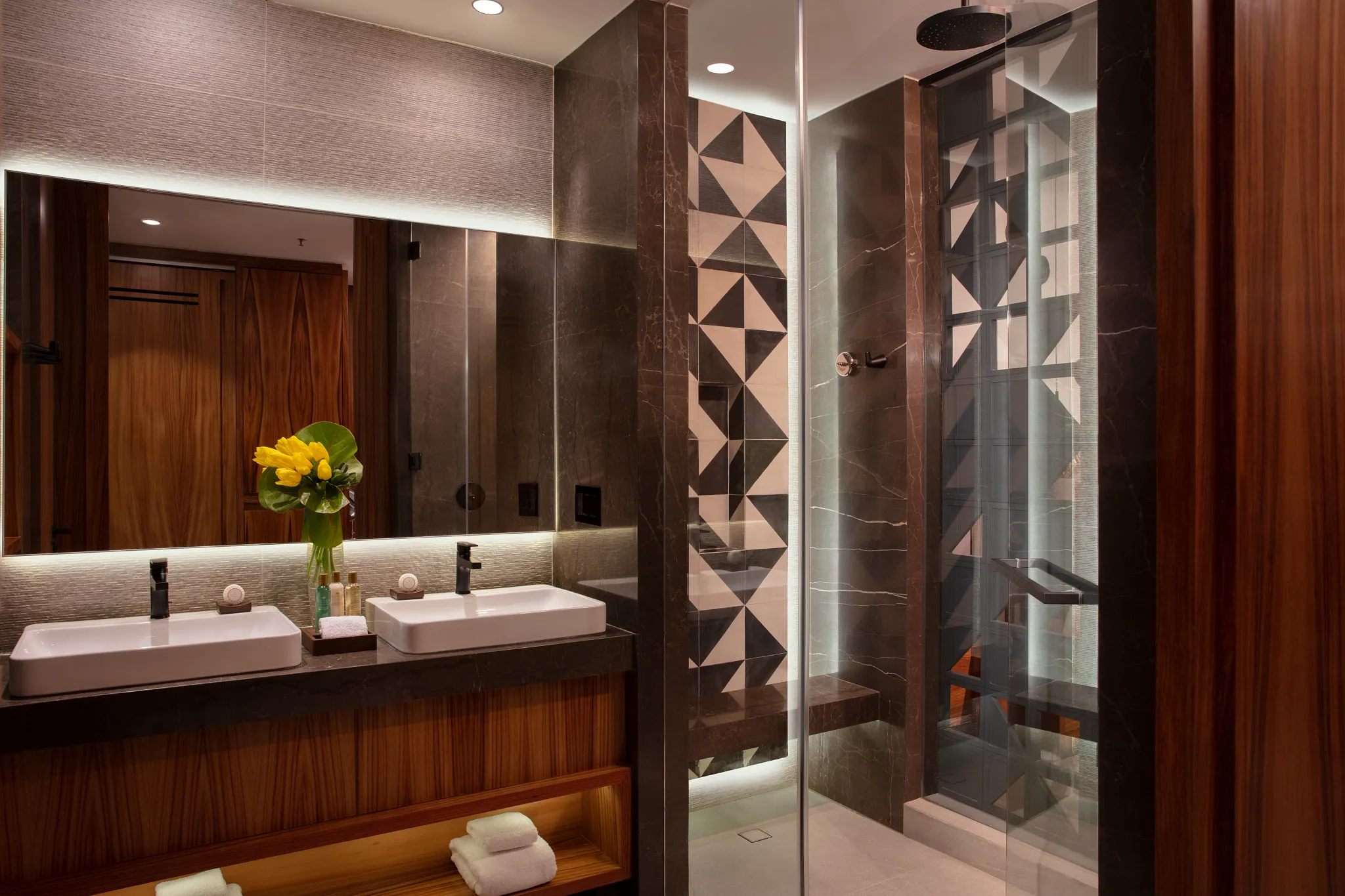 Junior Suite Tropical View bathroom with double vanity and glass-enclosed shower at Secrets Bahia Mita Surf & Spa Resort.