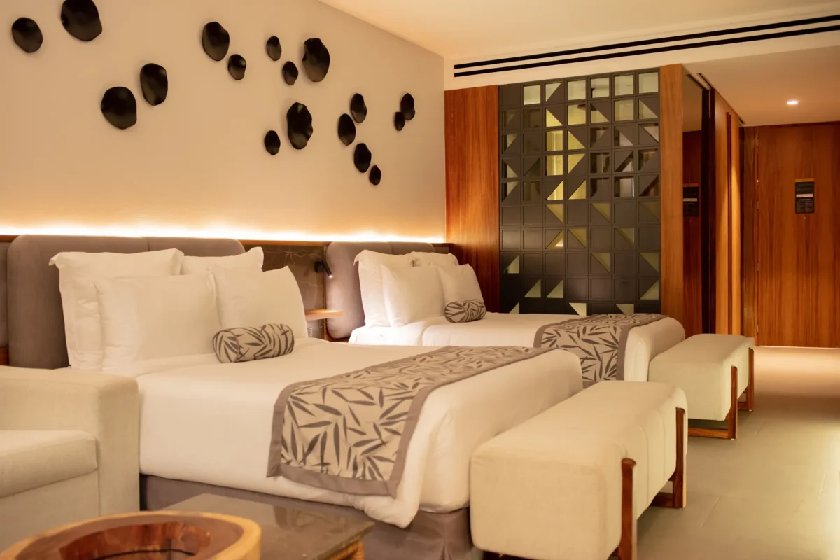 Junior Suite Tropical View with two queen beds and modern décor at Secrets Bahia Mita Surf & Spa Resort.