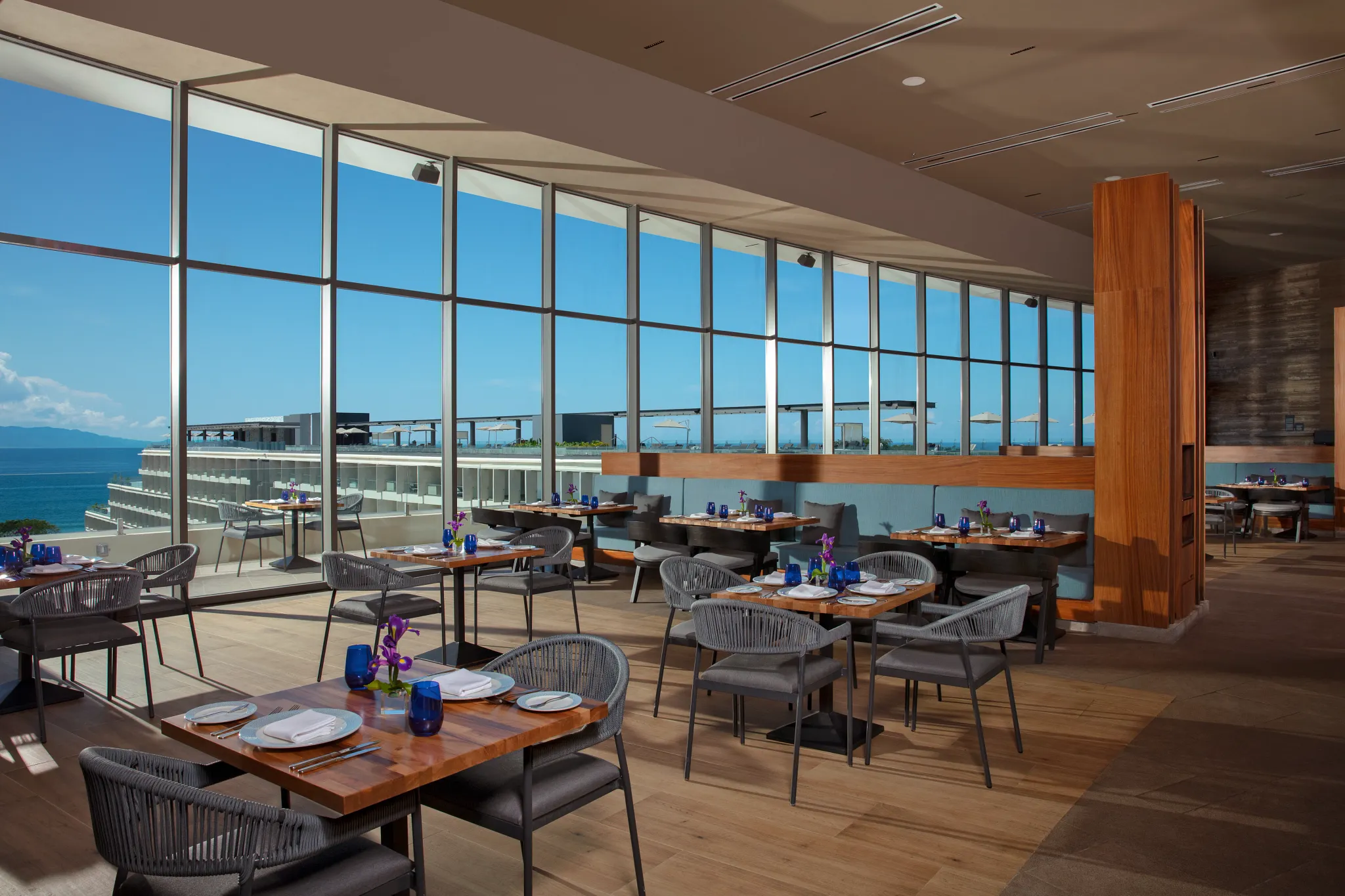 Market Café at Secrets Bahia Mita Surf & Spa Resort featuring a bright dining room with ocean views, modern seating, and international buffet stations.