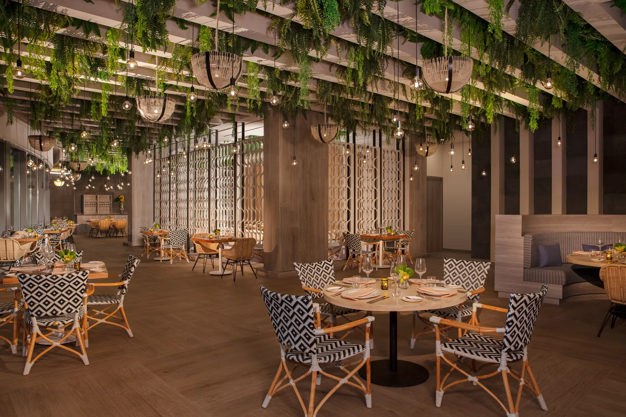 Portofino Italian Restaurant at Secrets Bahia Mita Surf & Spa Resort featuring an elegant dining room with lush greenery, warm lighting, and Mediterranean-inspired décor.