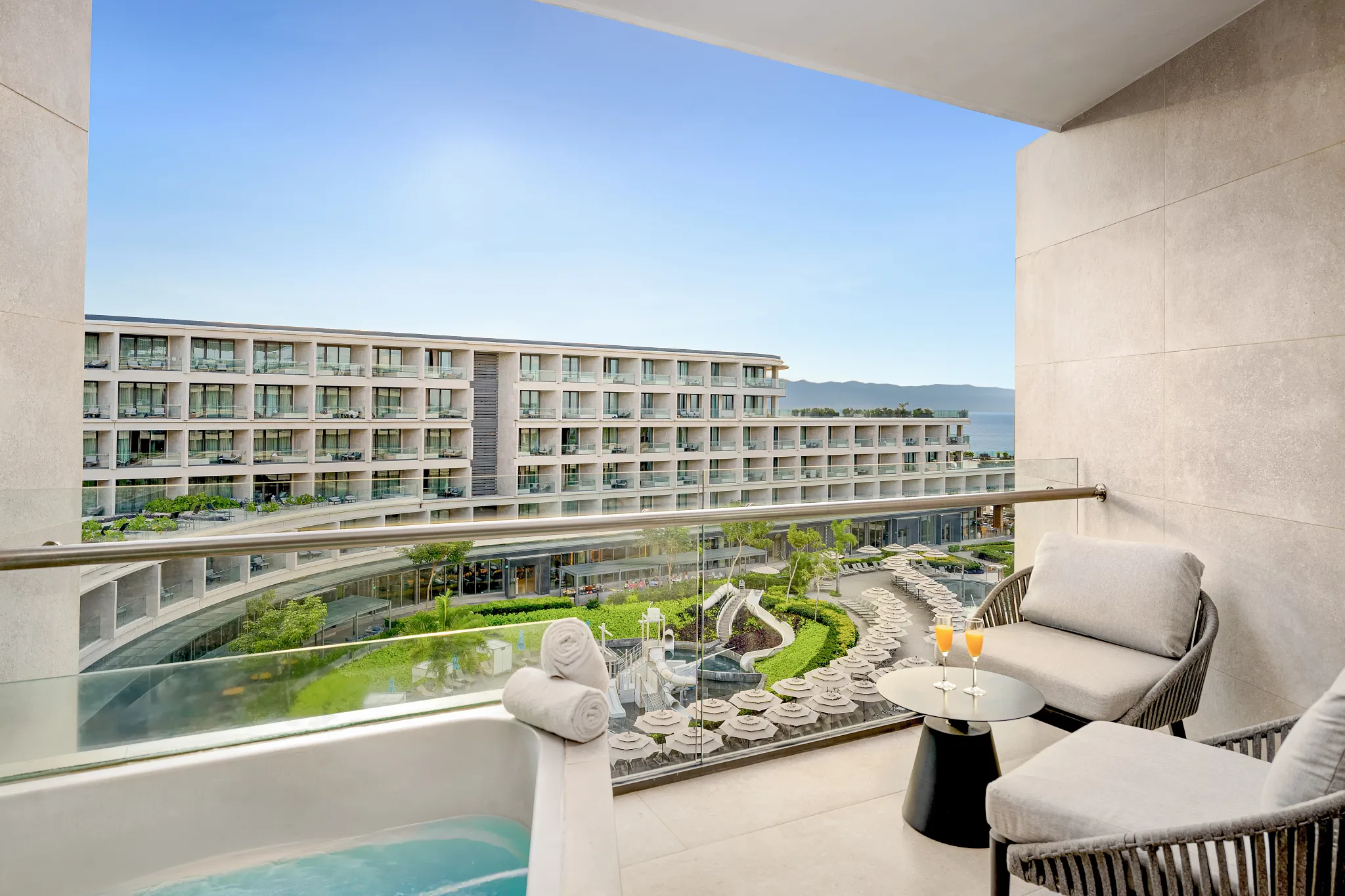 Preferred Club Ambition Suite Panoramic View terrace with soaking tub overlooking the resort pools and ocean at Secrets Bahia Mita Surf & Spa Resort.
