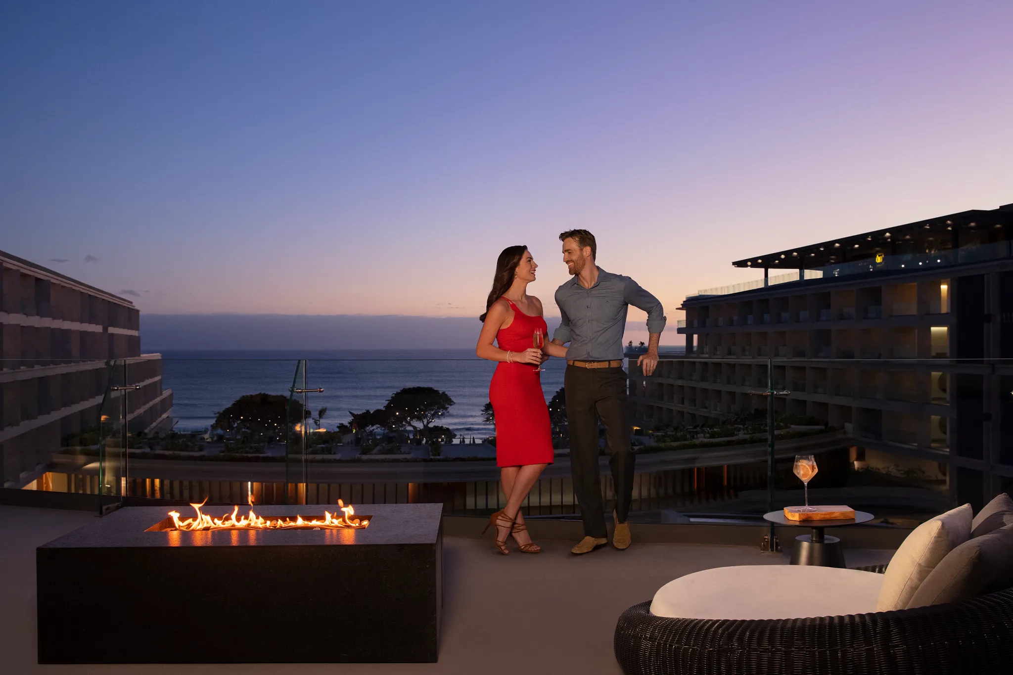 Couple enjoying evening cocktails on the Moon Deck terrace at Secrets Bahía Mita Surf & Spa Resort overlooking the ocean.