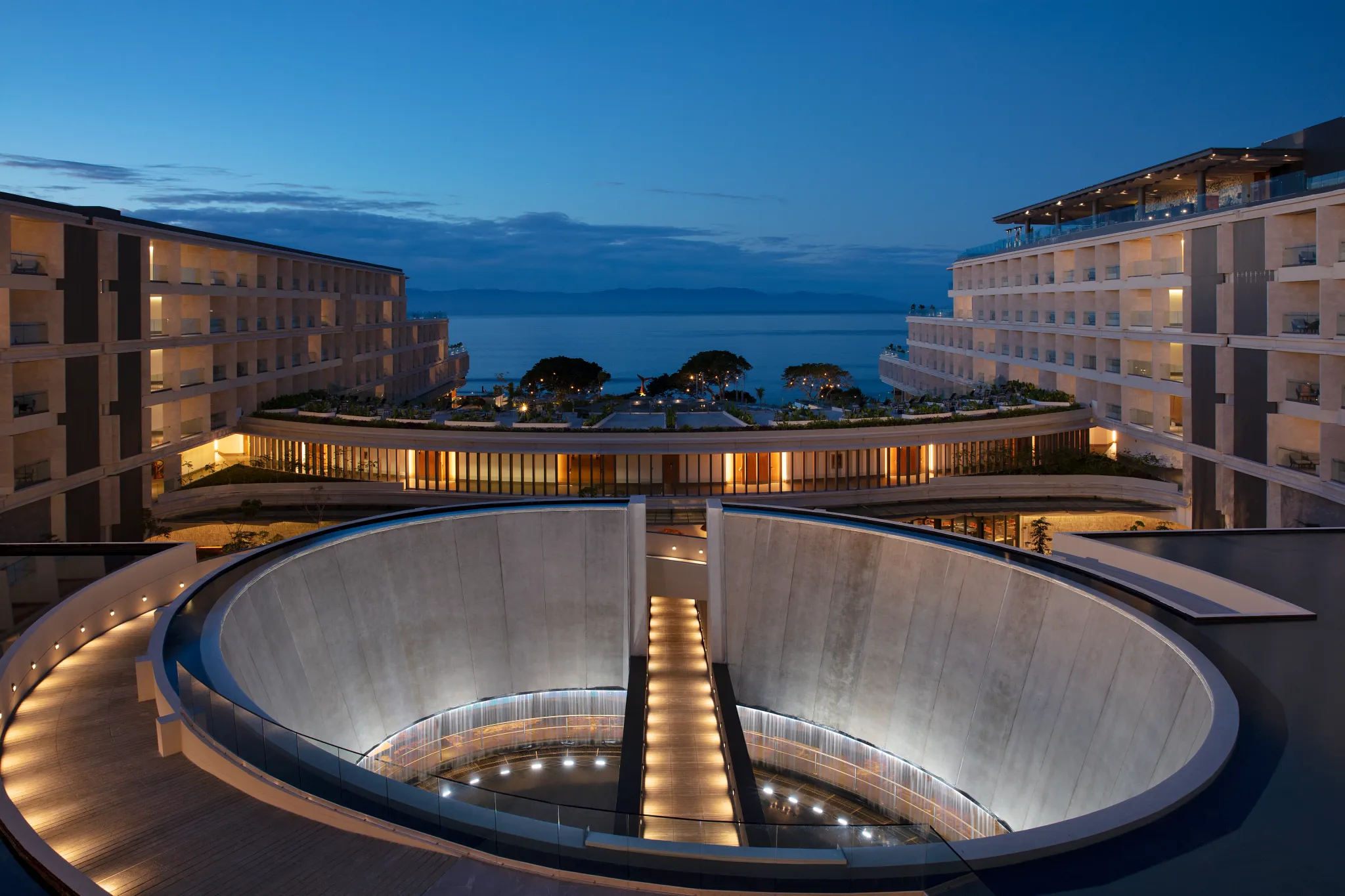 Twilight aerial view of Secrets Bahia Mita Surf & Spa Resort overlooking the Pacific Ocean at sunset.